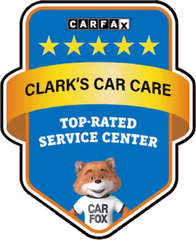 A blue and gold badge with five stars, Clarks Car Care, Top-Rated Service Center, and a cartoon fox wearing a Car Fox shirt at the bottom.
